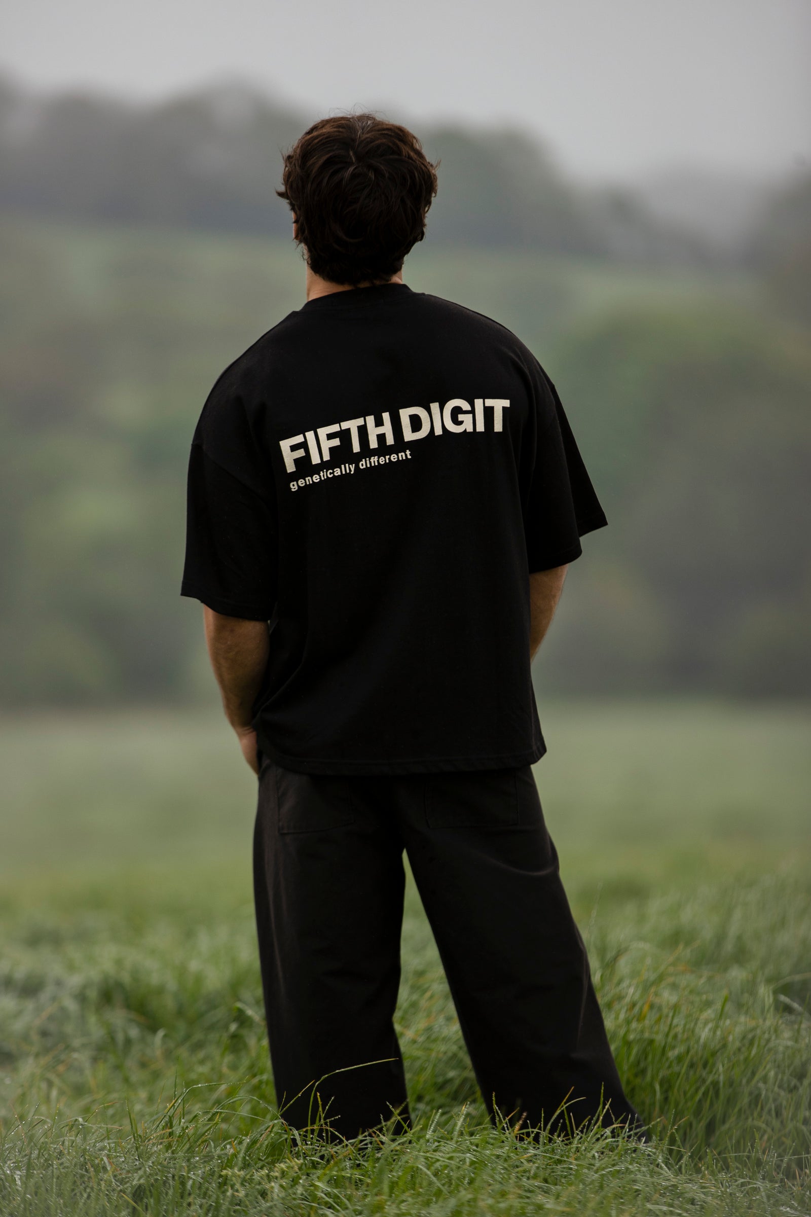 Fifth Digit Capsule 001 — back view of black tee, FIFTH DIGIT genetically different print, still figure