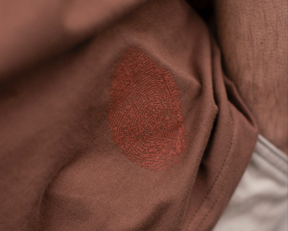 Fifth Digit Capsule 001 — close detail of orange thumbprint mark on vintage brown tee
