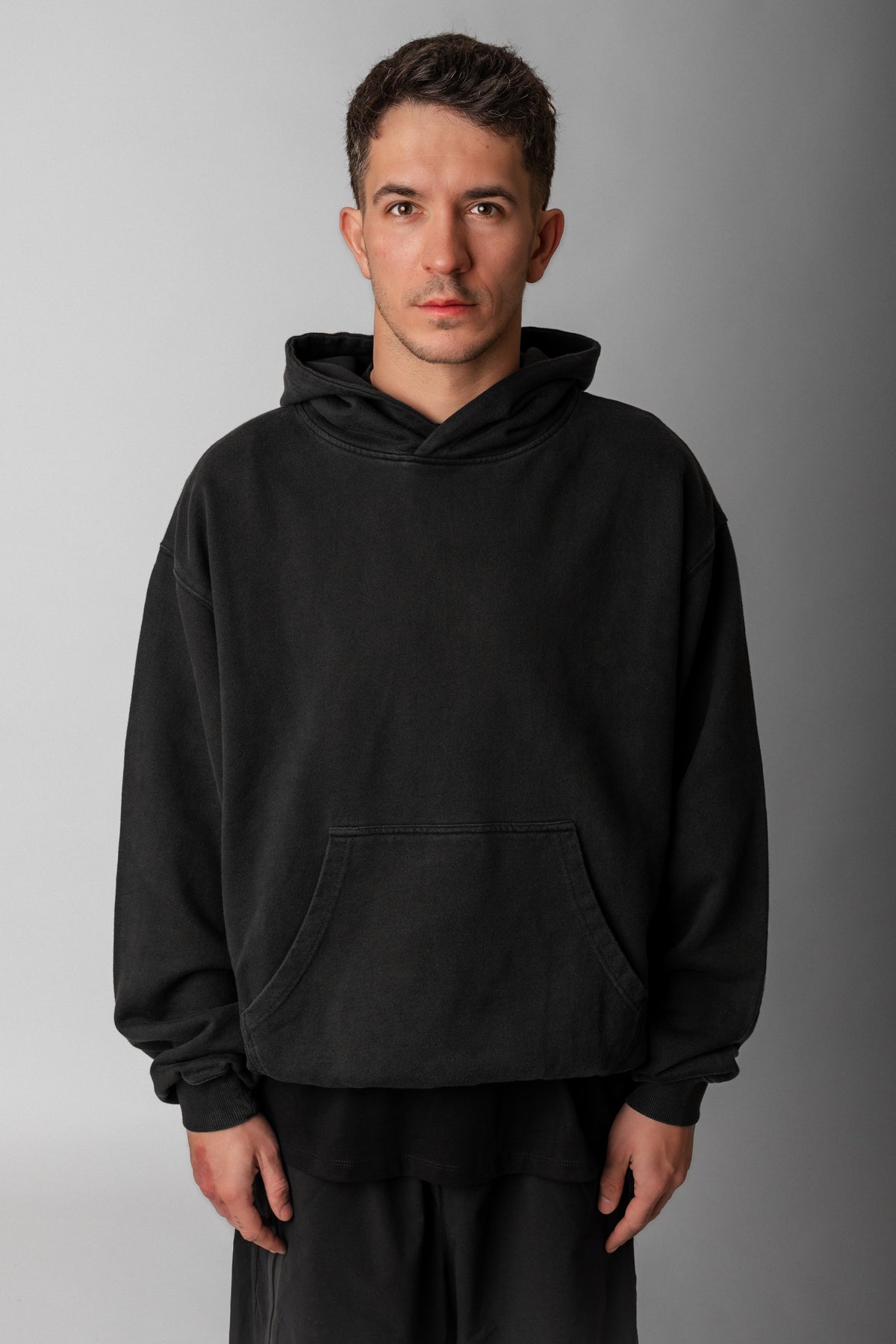 Model wearing Fifth Digit Frame 460gsm organic cotton hoodie in vintage black, front view