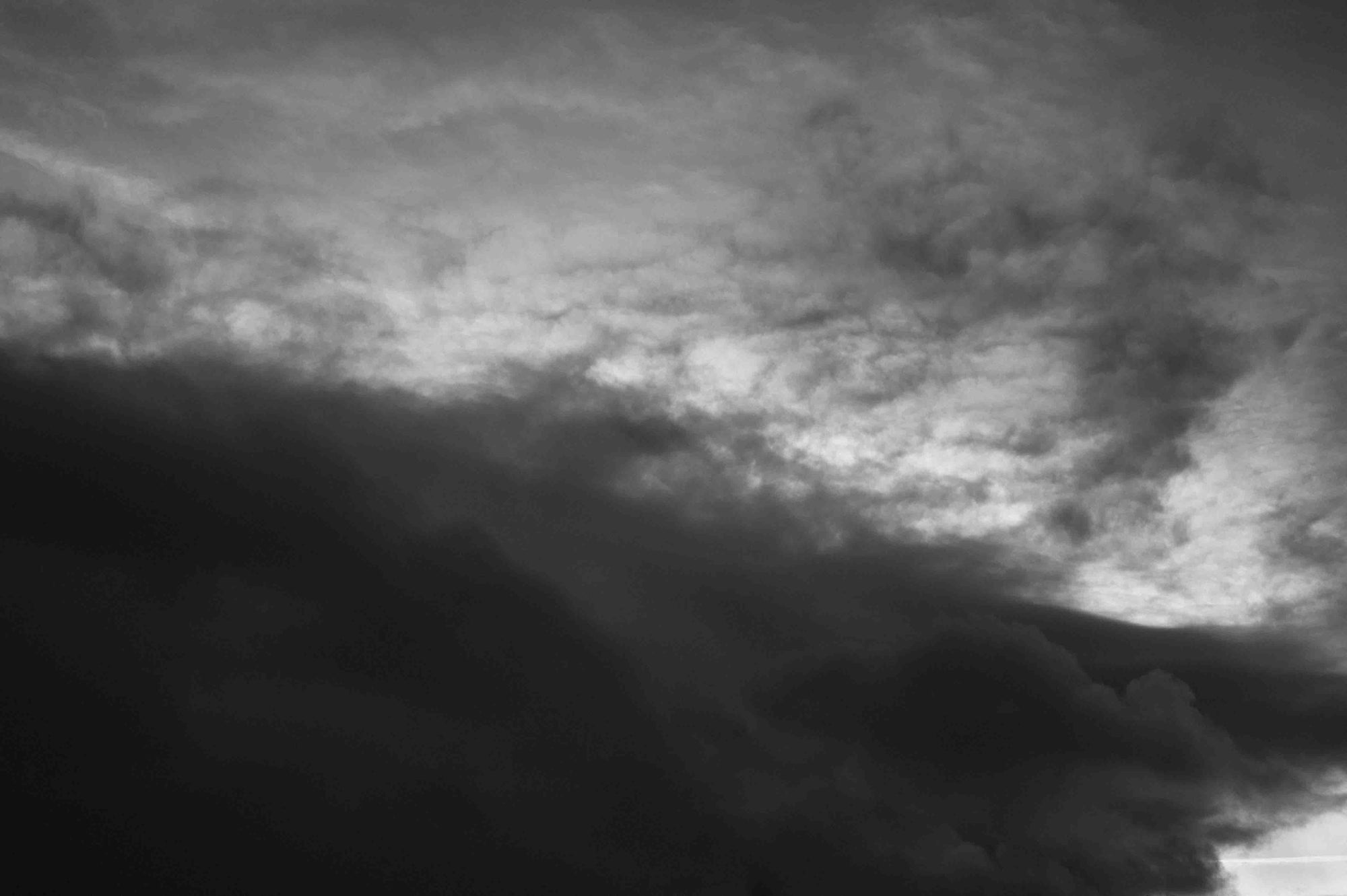 A wide sky with cloud and breaking light. Black and white.