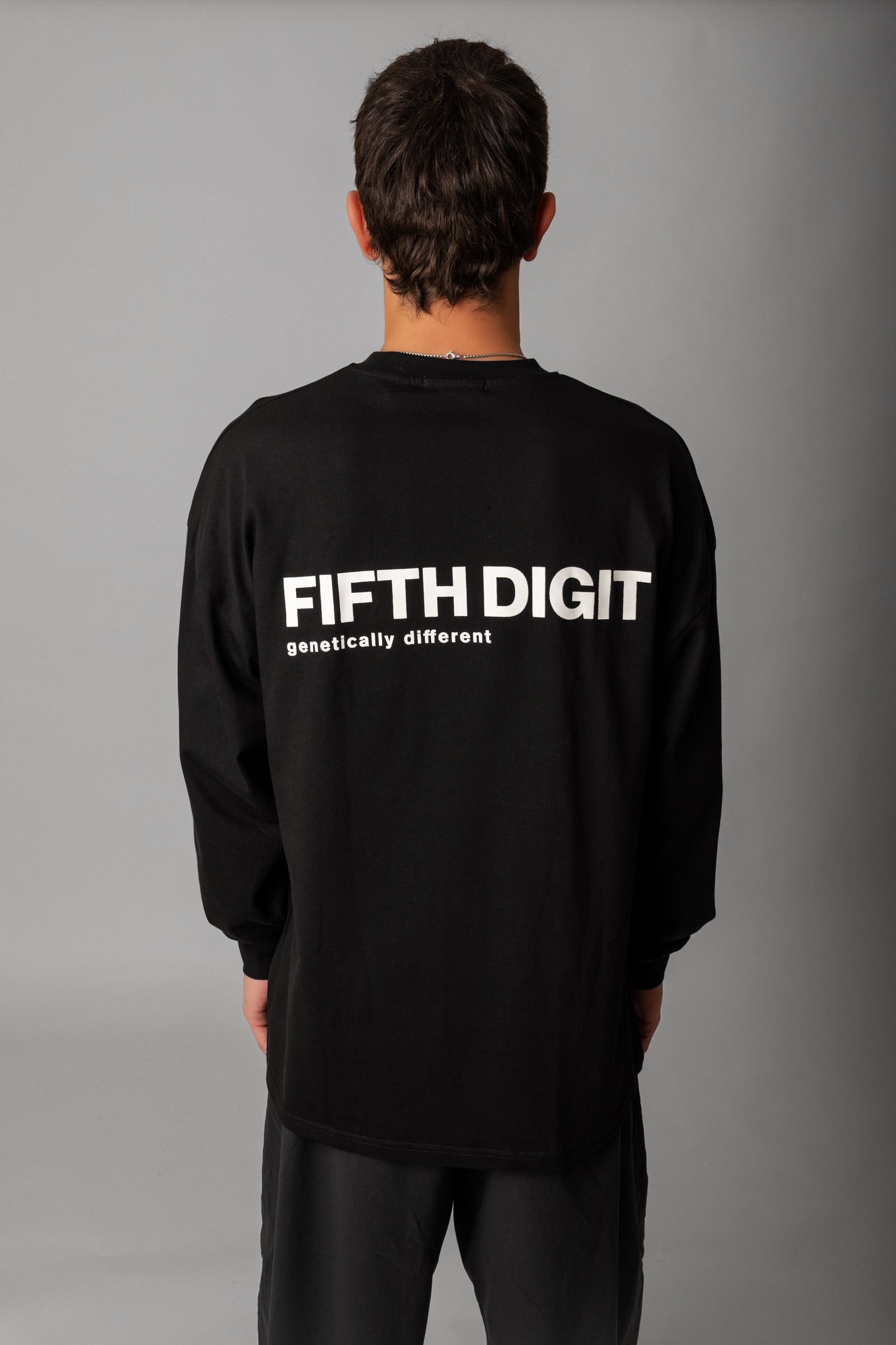 Model wearing Fifth Digit Origin 240gsm organic cotton long sleeve in black, back view with graphic print