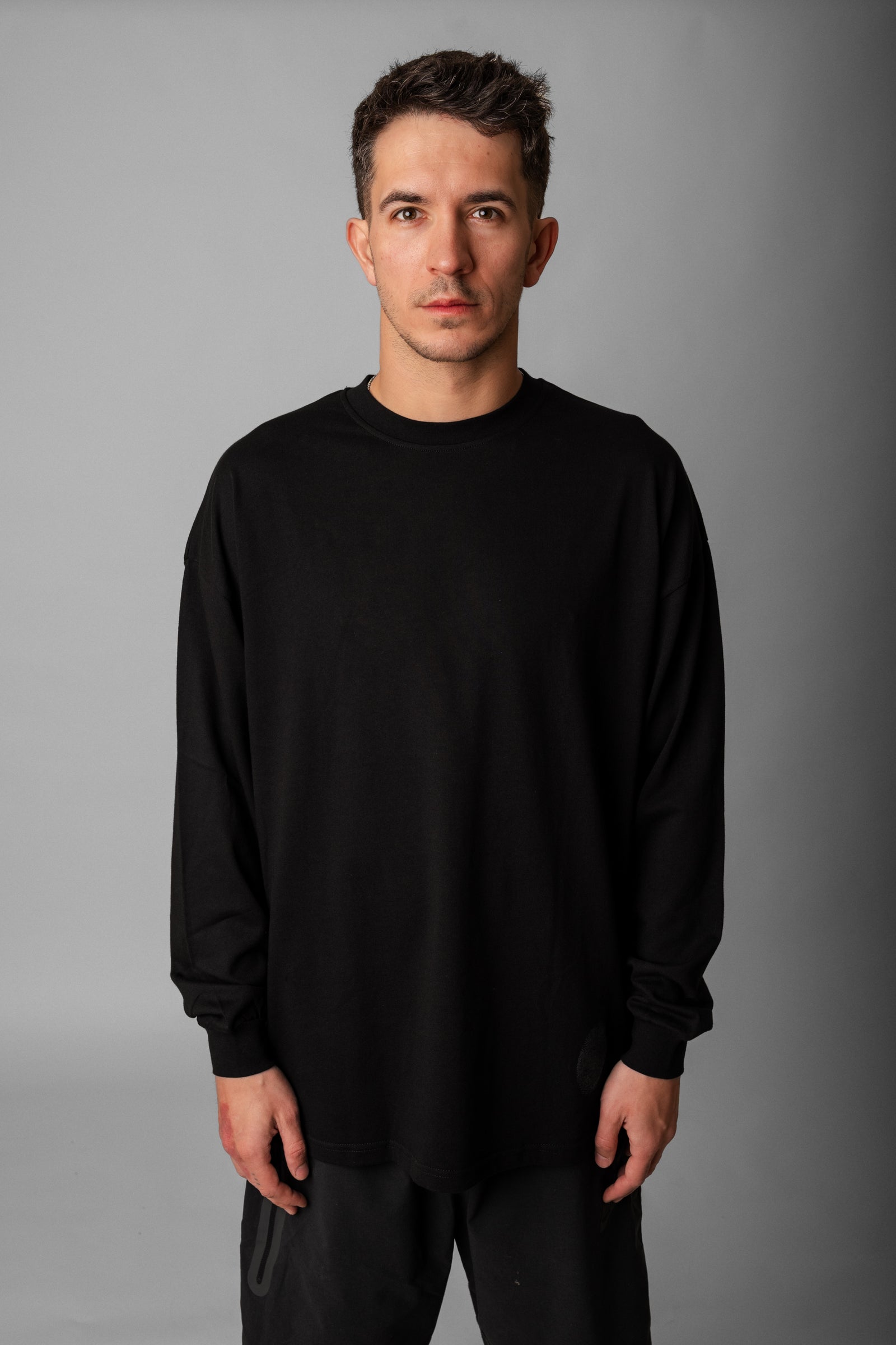 Model wearing Fifth Digit Origin 240gsm organic cotton long sleeve in black, front view