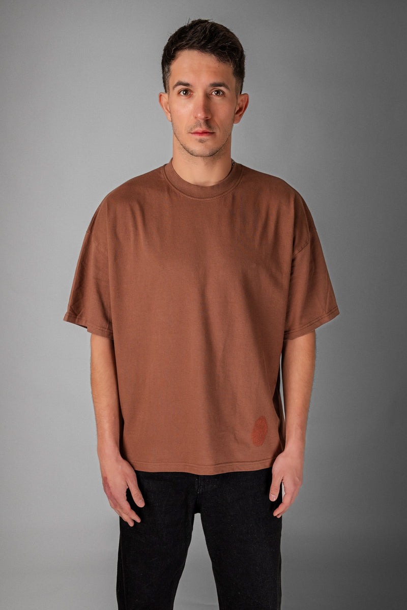 Model wearing Fifth Digit Pressure 240gsm organic cotton tee in vintage brown, front view