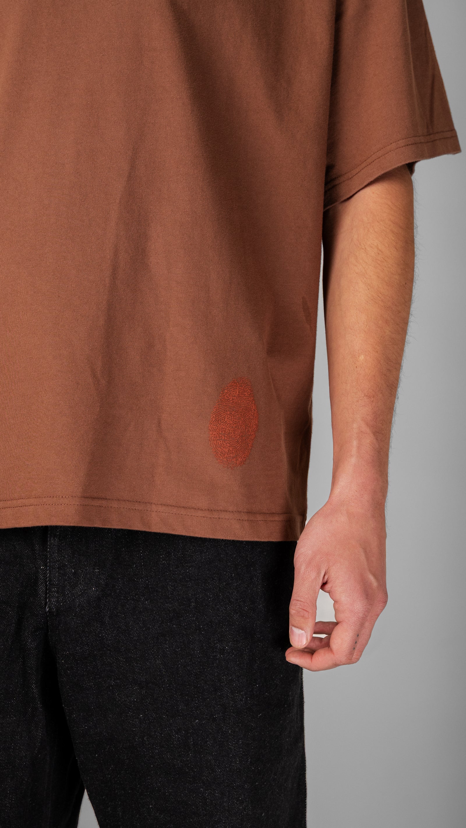 Model wearing Fifth Digit Pressure 240gsm organic cotton tee in vintage brown, side view