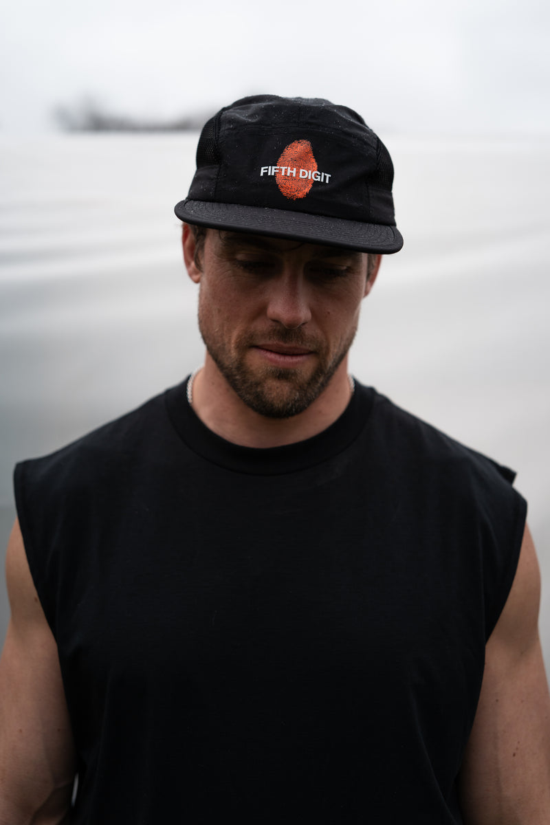 Model wearing Fifth Digit Runner structured cap in black, front view